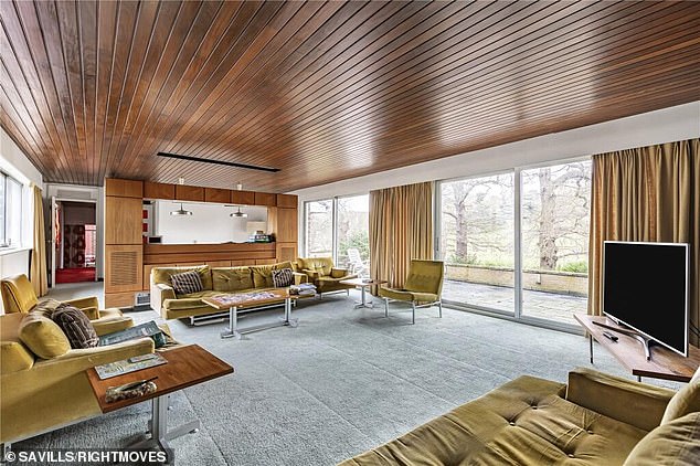 The living room on the first floor with expansive views of Richmond Park. And despite having been a home for 58 years, the decor and period furniture is enough to transport any would-be buyer back to the swinging sixties