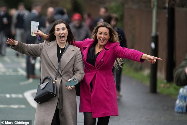 Smiling racegoers make their way to Cheltenham Festival yesterday