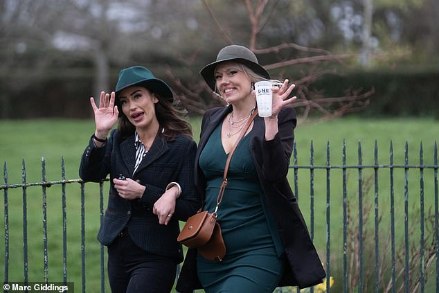 More fashionable attendees at Cheltenham Festival wave as they prepare for another day of fun yesterday