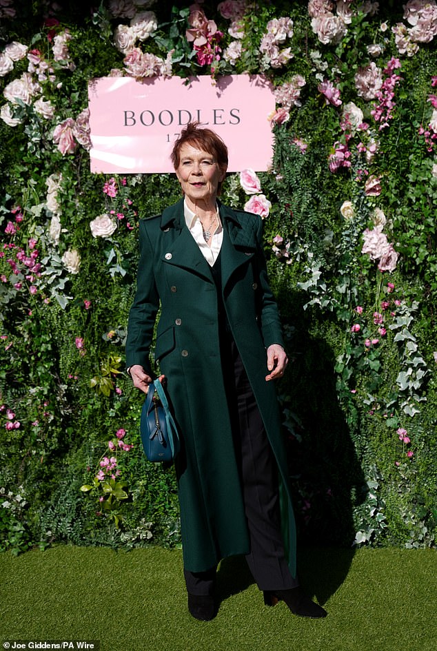 Celia Imrie wore a dark green coat over a black jacket and matching trousers