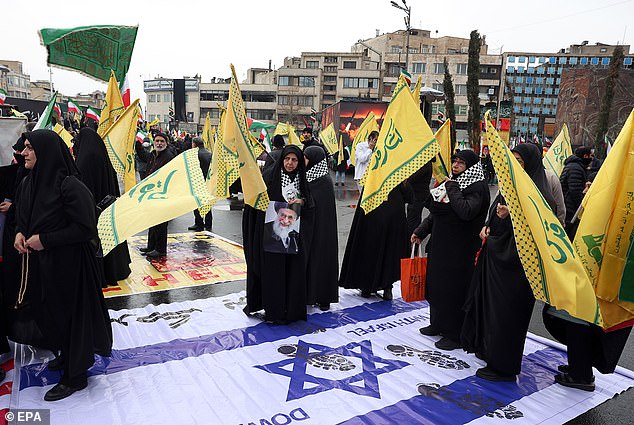 Iranians step on an Israeli flag during a rally in Tehran, Iran, 13 March