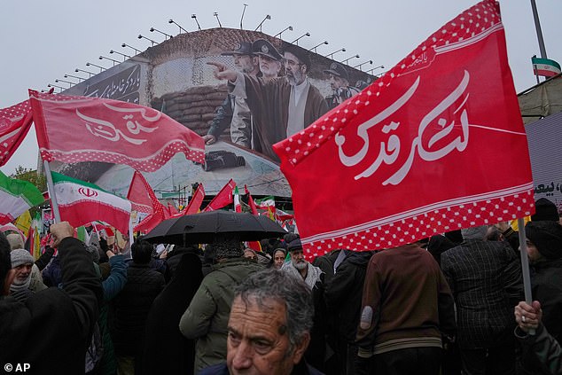 A billboard shows a graphic depicting Iran's Supreme Leader Ayatollah Mojtaba Khamenei with military commanders as people attend the annual anti-Israeli Quds Day in Tehran on March 13