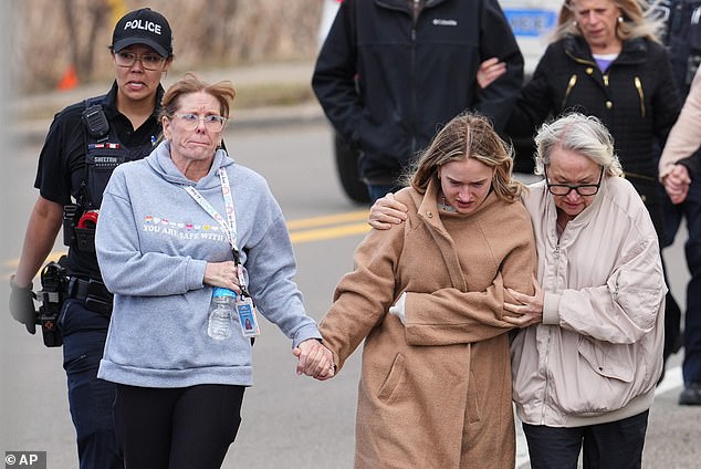 Law enforcement escort families away from the Temple Israel synagogue on Thursday, in West Bloomfield Township, Michigan