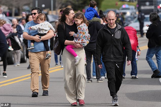 Parents carry their preschool aged children to safety as police escort them away from Temple Israel synagogue after Ghazali's attack Thursday