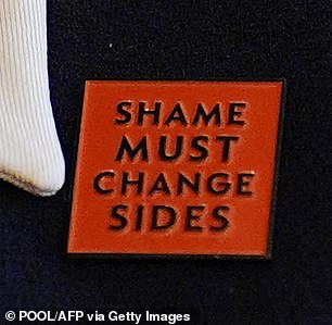 The Queen wore a badge that said 'Shame must change sides'