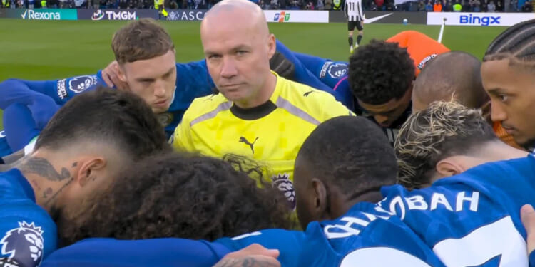 Referee Paul Tierney awkwardly gets caught right in the middle of Chelsea huddle before Newcastle clash