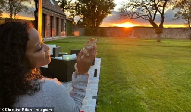 Christina is pictured enjoying the sunset in the garden of her French home