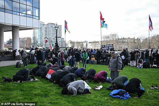 Demonstrators gathered on the South Bank of the Thames for prayers and brandished a placard declaring 'US Israel hands off Iran'