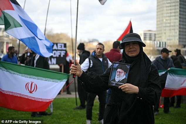 A pro-Iran demonstrator holds a framed pictured of the assassinated Ayatollah Ali Khamenei alongside the words 'honour and dignity' - London, March 15, 2026