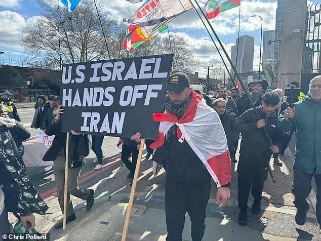 Pro-Iran demonstrators gathered by the Thames and brandished a placard declaring 'US Israel hands off Iran'