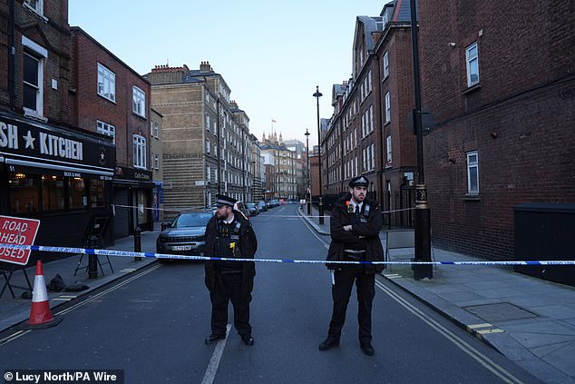 Police stood guard beside a cordon in Horseferry Road in Westminster, London, following reports that a baby had fallen from a height on Saturday