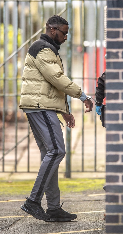 Gift Oladele arriving in handcuffs at Mold courts for his rape trial.