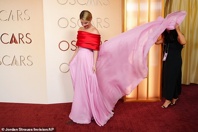 As she arrived in her eye-catching gown, Jessie received a helping hand with showcasing the long skirt from her look
