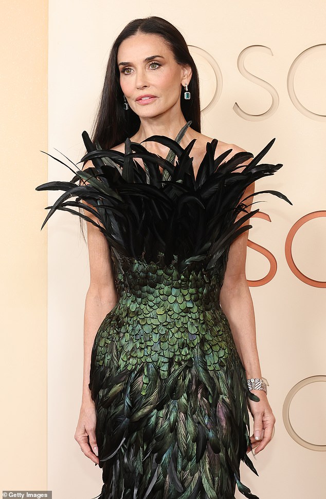 The over-the-top dress contained dramatic feathers all over the chest area and flowing skirt, as well as scales along the midriff