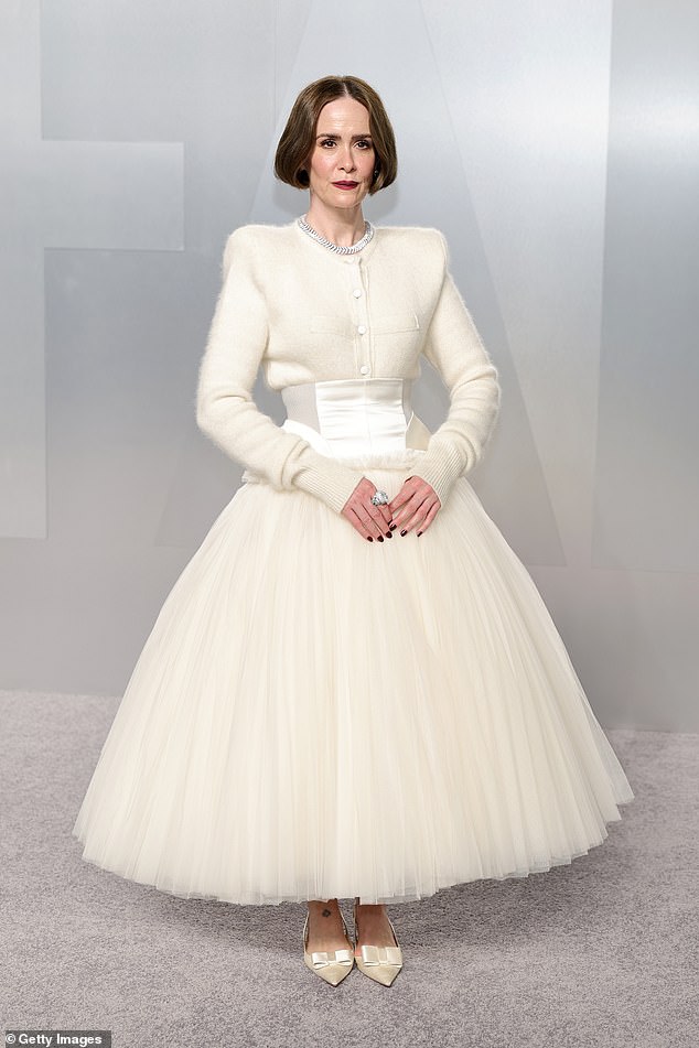 Sarah Paulson, 51, also went for an all-white ensemble that included a thick-long sleeve button-up and a ballooning, crimped skirt, with the mismatched materials making her stance appear a little awkward