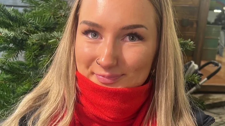 Olivia Wojciechowska, a young woman with long blonde hair, a red scarf, and a nose ring, smiling gently.
