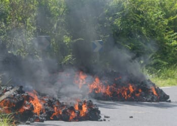 Stunning footage shows flaming lava slowly creep across road and meet the ocean after tropical island volcano eruption