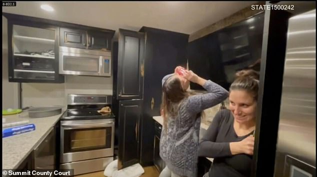 Kouri Richins smiles during a 'Celebration of Life' one day after her husband's death - while a woman in the background shotguns a can of beer
