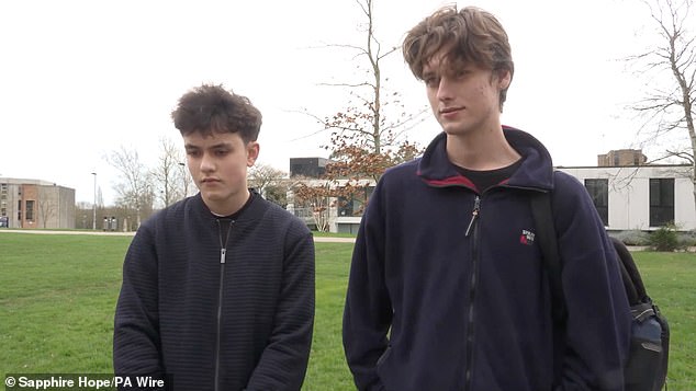 Matthew (left), 16, and Luca McDonagh (right), 17, in the queue for antibiotics at the University of Kent in Canterbury on Monday
