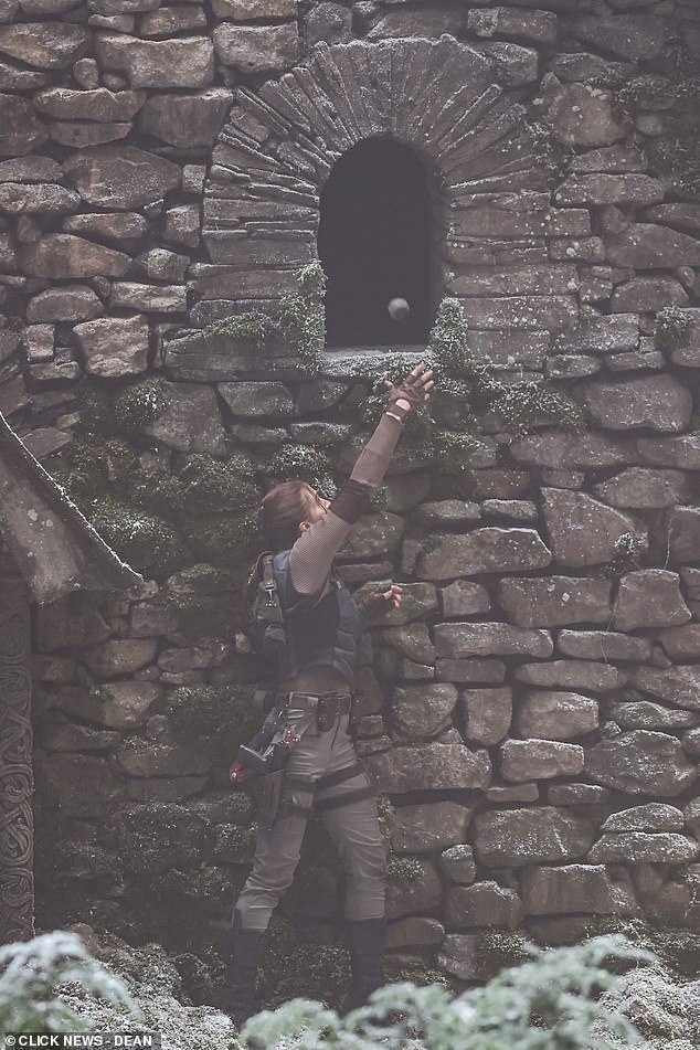 The Game Of Thrones star was seen sheltering against the stone wall before throwing a weapon through a small window