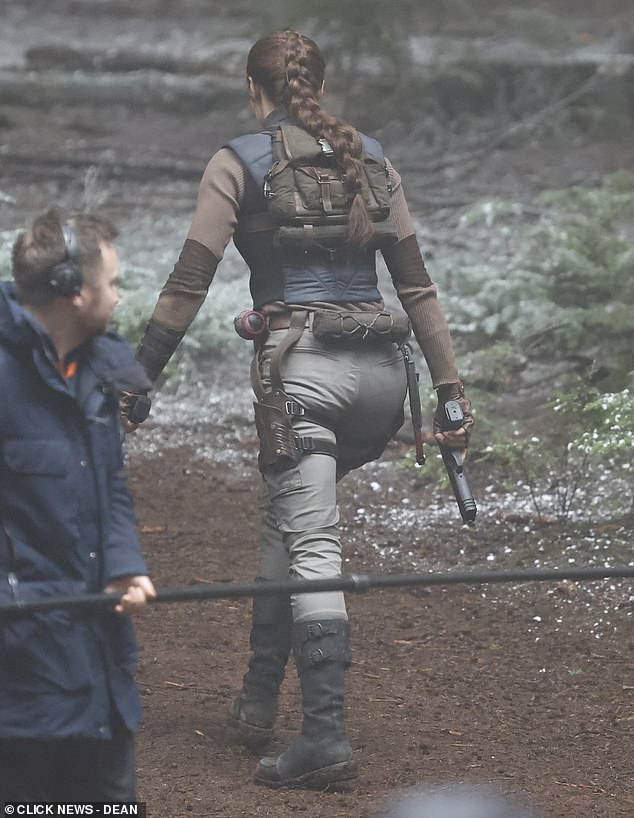 She rocked a pair of khaki cargo trousers with a brown jumper and a blue waistcoat layered over the top