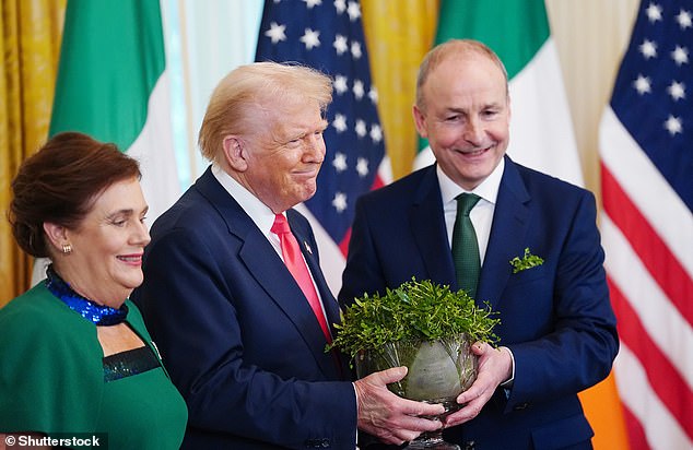 The Irish leader, right, and O'Shea present Donald Trump with the traditional shamrock bowl during a St Patrick's Day reception in the East Room of the White House in March 2025
