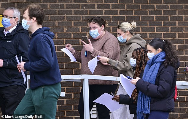 Students wear face masks outside the University of Kent today as they queue for antibiotics