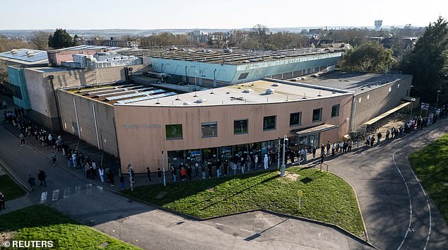 A huge queue of university students snakes around the Sports centre on the University of Kent campus where people are receiving vaccines