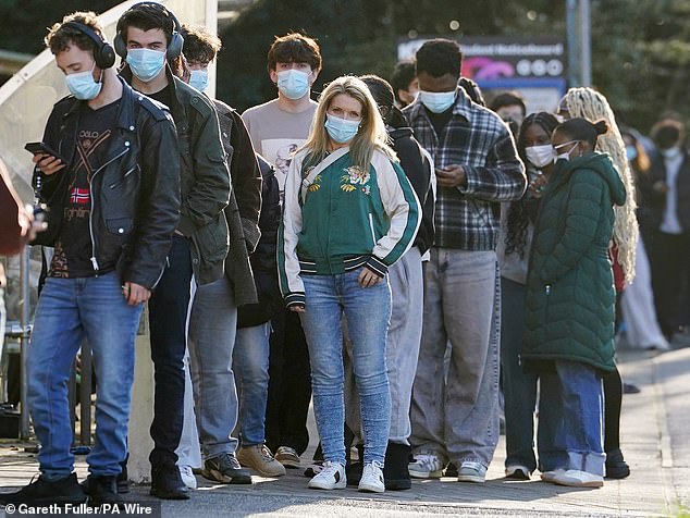 Students wait in line at the entrance to the sports hall at the University of Kent, where the rollout of a meningitis B vaccine to about 5,000 students began on Wednesday