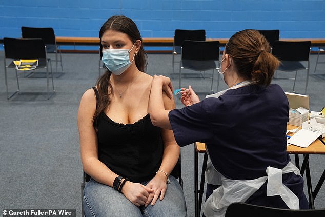 A student receives a vaccine in the sports hall at the University of Kent in Canterbury today