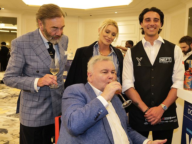 Holmes enjoyed a tipple as girlfriend Alexander and competition president Robert Walton MBE (L) looked on