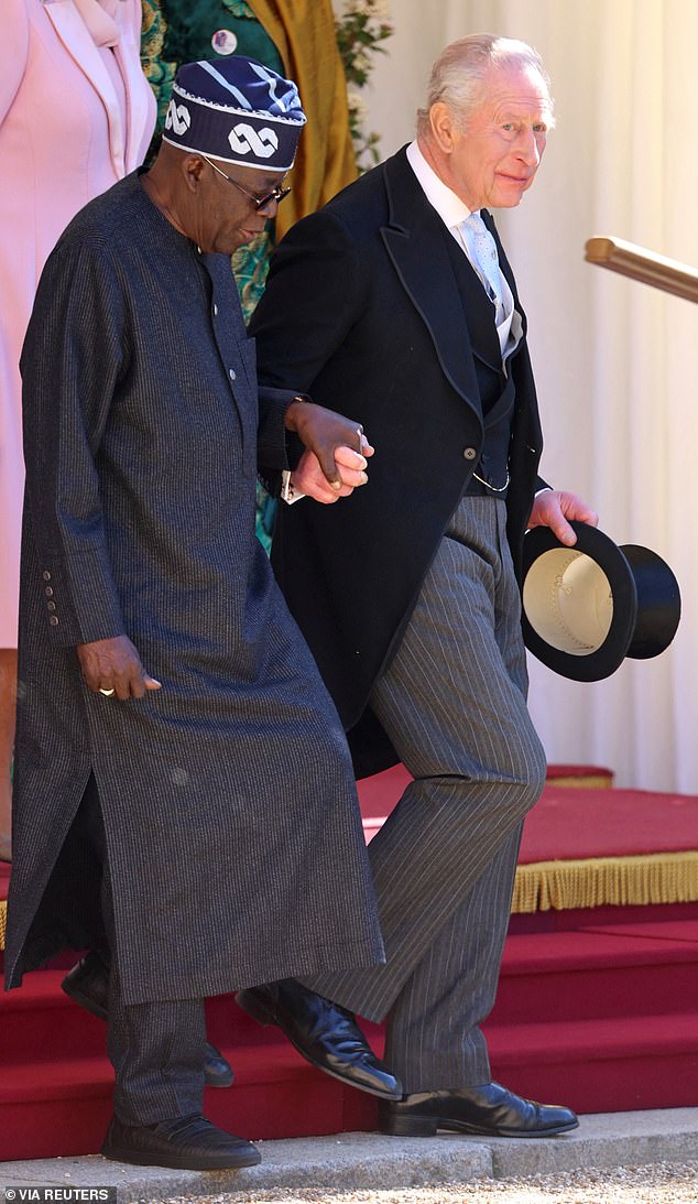Following a ceremonial welcome in the Quadrangle, at Windsor, royal commentators were surprised by a 'rare' gesture from the King, who offered his hand to Mr Tinubu as they walked in Windsor