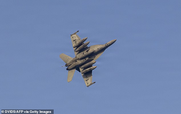 A US Navy F/A-18E Super Hornet, attached to Strike Fighter Squadron (VFA) 151, flies over Nimitz-class aircraft carrier USS Abraham Lincoln (CVN 72), during Operation Epic Fury