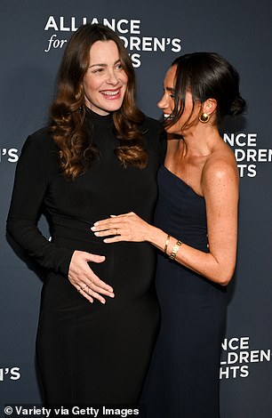 Meghan was invited to cradle her bump