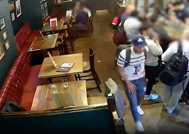 Abderaouf walks past a rucksack that he later made off with. The bag is pictured in the bottom left of this video grab