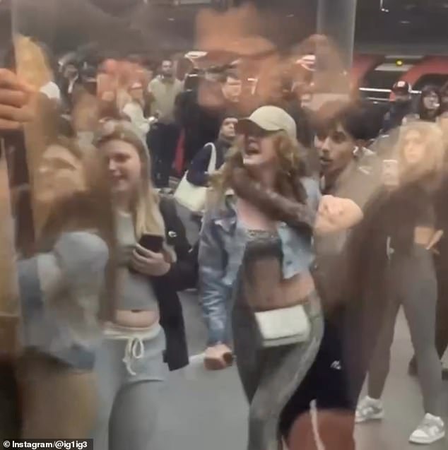 The girl is held back by her friends on the platform at Stratford station in east London