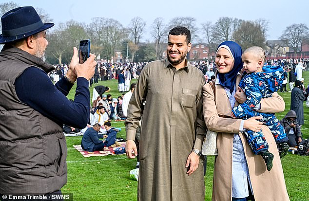 A family poses for photographs at Small Heath Park, where between 20,000 and 30,000 people were expected to gather today