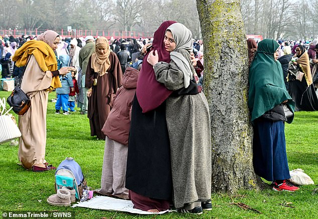 Two women hug one another during a celebration of Eid al-Fitr at Birmingham's Small Heath Park on Friday
