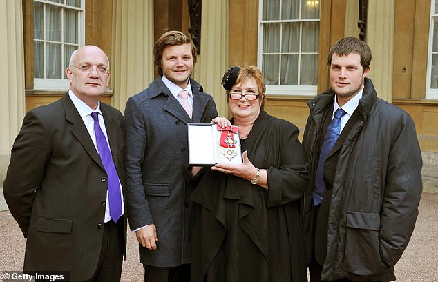 Jenni was made a Dame in in 2011. Pictured with her husband David and sons Charlie, second left, and Ed