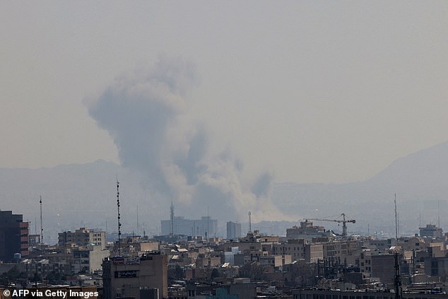 A plume of smoke rises from the site of a strike in Tehran on March 17, 2026