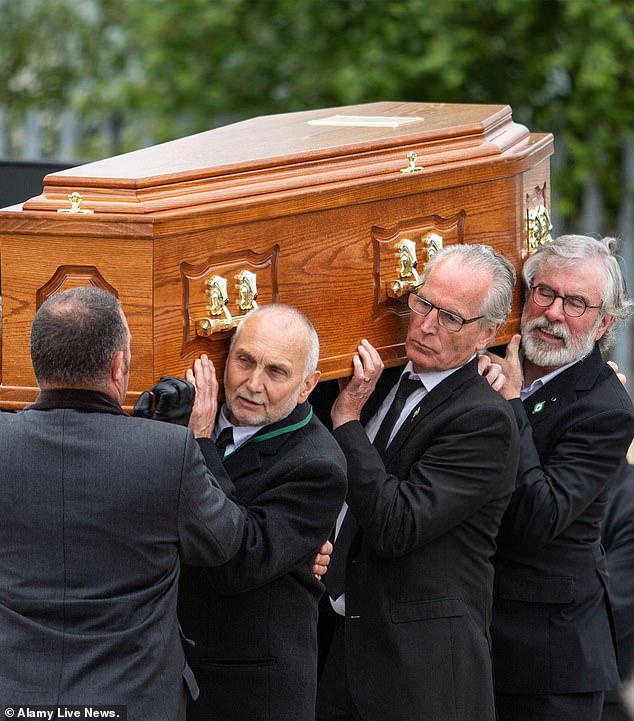 Pallbearers (left-to-right, with faces visible): Sean Murray, Gerry Kelly and Gerry Adams carry Bobby Storey's coffin on June 30, 2020, in Belfast