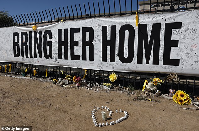 Candles and flowers are placed at a Nanthy Guthrie memorial in front of the KVOA news station on March 03, 2026 in Tucson, Arizona