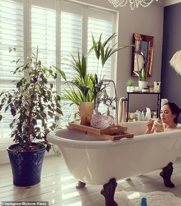 With hardwood flooring, a free-standing bathtub and even a chandelier overhead, Myleene's luxurious space is fit with trendy shutters and a plant carefully placed on a wooden bath stand