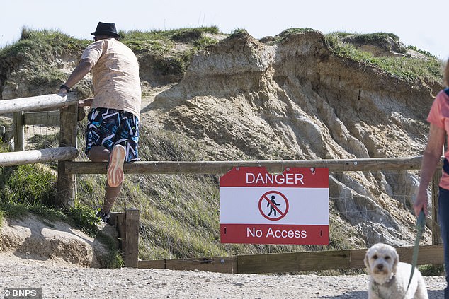 However foolish visitors were seen squeezing their way past the barrier, which read 'Danger: No Access', to enjoy the beach on Sunday