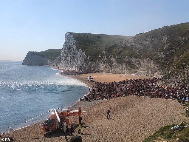Hundreds of beachgoers crammed together to make room for an air ambulance which was responding to reports that four people jumped off the 200ft cliff in May 2020