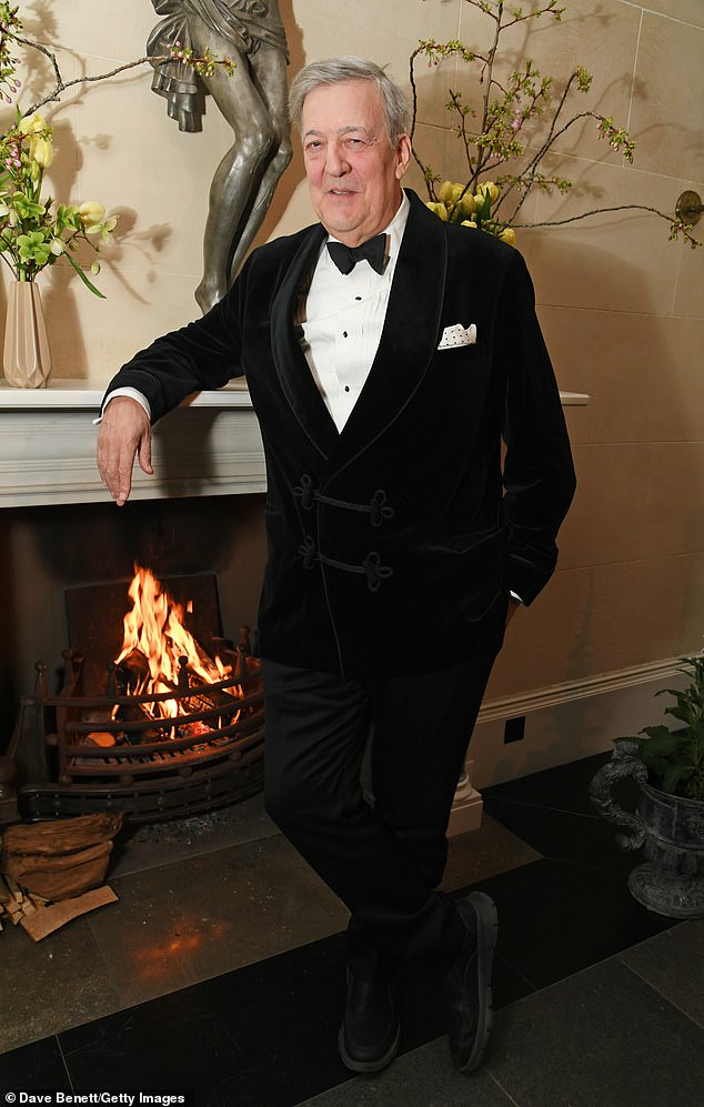 Sir Stephen Fry cut a dapper figure in a  black velvet suit