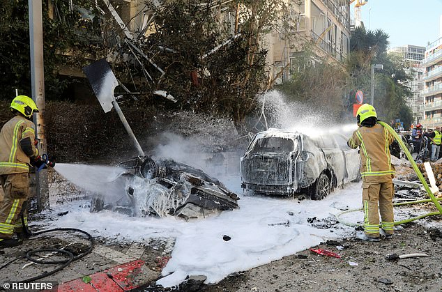 Israeli firefighters work to put out a fire following Iranian missile strikes on Israel on March 24