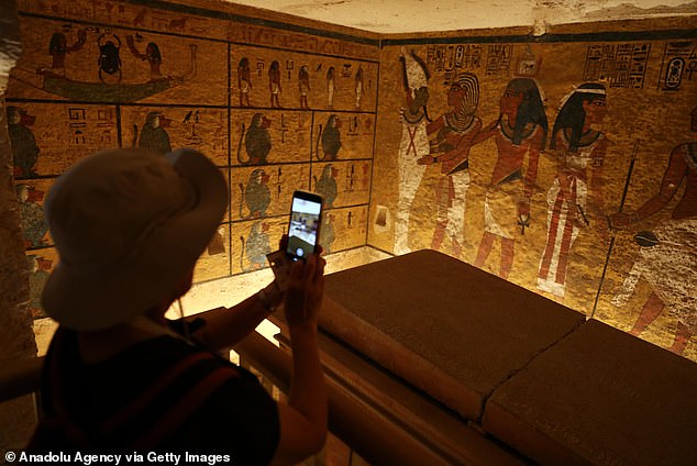 Visitors take photos inside Tutankhamun's burial chamber in the Valley of the Kings in 2022