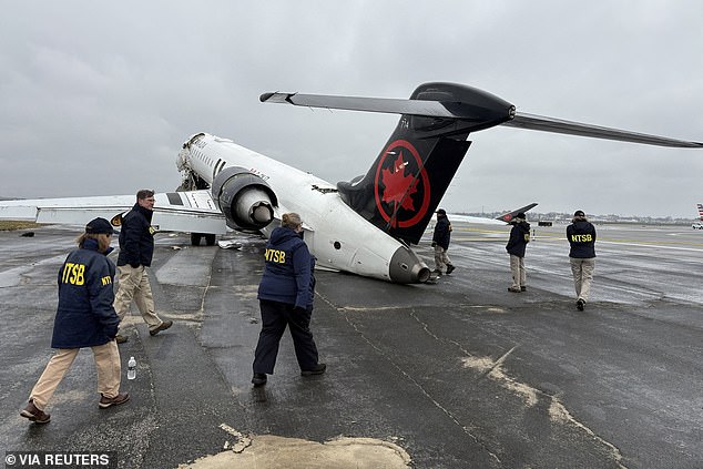 National Transportation Safety Board investigators inspect the wreckage at LaGuardia Airport on Monday