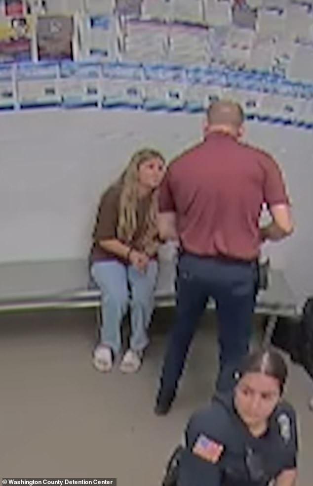 She was also seen sitting on a bench with cuffs on as she talked to an officer